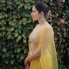 A profile shot showcasing the bride's elegant hairstyle and the intricate hair accessory woven into her braid.