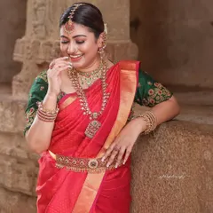 A relaxed and happy portrait of a bride leaning against a carved stone pillar. The intricate details of the temple architecture provide a stunning backdrop.