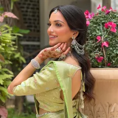 A side profile showcasing the intricate details of this South Indian bridal look. The soft makeup complements the stunning jewelry and hairstyle, creating a harmonious and radiant appearance.