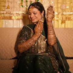 A bride proudly showing off her intricate Mehendi. I focus on capturing the details of the henna art, a significant part of the pre-wedding celebration, while also catching the bride's happy and content expression.