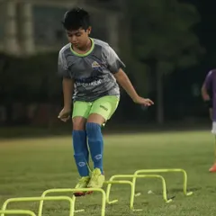 A young player working on his agility and footwork over hurdles. These fundamental drills build the foundation for advanced skills.