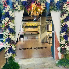 A lush floral archway designed for a corporate event at a Jaquar showroom. The mix of blue, white, and purple flowers with a central chandelier adds a touch of elegance and sophistication to the entrance.