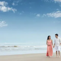 Let's take our session outdoors. A walk on the beach at sunset provides a beautiful, natural backdrop for capturing candid moments. Here, we see a couple sharing a quiet moment, with the open sky and sea creating a feeling of infinite possibility.