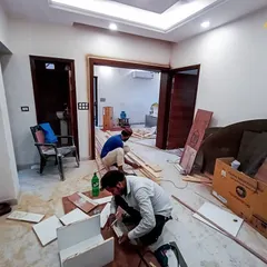 A snapshot of our team at work on-site. This image shows carpenters assembling custom furniture inside a home, demonstrating our hands-on approach to execution and attention to detail during the construction phase.