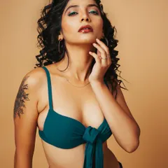 A vibrant swimwear shoot with a focus on creative makeup. The teal bikini top is complemented by the pop of color in the eyeshadow, creating a fresh and edgy look for a model's book.