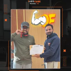 Celebrating another member's achievement. Here, one of our clients proudly holds his certificate and medal, marking a personal milestone in his fitness journey with his trainer by his side.