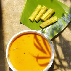 This Drumsticks and Raw Mango Curry, or Muringakka Manga Ozhichukootan, is a dish guided by instinct and memory. The raw mango lends a sharp acidity, drumsticks add an earthy depth, and coconut wraps it all in a fatty embrace.