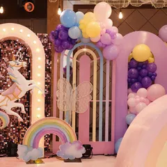A closer look at the unicorn birthday party entrance, featuring a life-sized carousel unicorn against a sparkling sequin backdrop and a balloon-decorated gate. First impressions matter!