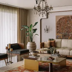 The color palette for this living room was all about celebrating minimalism with warm, earthy tones from the traditional Indian palette. The custom-painted Kalamkari art, leather sofa, and 'velaku' inspired side table come together to create a cozy, sophisticated space.