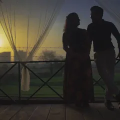 Using the early morning light to create a powerful silhouette. This pre-wedding photo captures a quiet, intimate conversation between the couple against a sunrise, symbolizing a new day and a new life together.