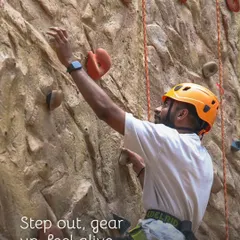 Step out, gear up, and feel alive. A guest gets ready to tackle our climbing wall, fully equipped with professional safety gear including a helmet and harness provided by us.