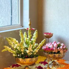 A close-up of the traditional floral arrangements. Details like brass urlis with lotus buds and tuberose flowers add a touch of authentic elegance to the venue styling.