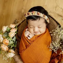 That sleepy newborn smile is just priceless. For my posed newborn sessions, I bring soft wraps, beautiful props, and a lot of patience to capture these peaceful, angelic portraits right in your home.