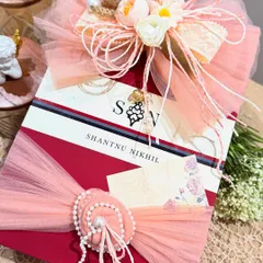 The right packaging elevates everything. Here, we've wrapped a designer box from Shantnu & Nikhil with soft peach tulle, a handcrafted floral bow, and a delicate pearl embellishment, turning a beautiful gift into an unforgettable experience.