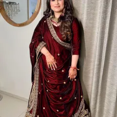 The sister of the bride looking absolutely regal in a deep red velvet ensemble. Her makeup is kept soft and natural to balance the richness of her outfit.