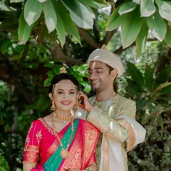 A sweet moment between a Maharashtrian bride and groom, as he helps her with her jewelry during their wedding ceremony.