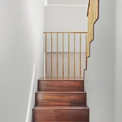 We believe even functional elements can be art. This dog-legged staircase, crafted from rich teak wood and accented with brass, is a sculptural centerpiece that also cleverly incorporates hidden storage, demonstrating our focus on integrated and thoughtful design.