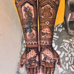 This bridal design tells a story with elephants on the palms, a doli motif, the wedding date, and the groom's initial, making it deeply personal for the bride.