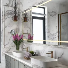Luxury lies in the details. In this master bathroom, we paired dramatic book-matched Italian marble with a custom sage green vanity and brushed gold fixtures. The result is a serene and sophisticated sanctuary, proving that functional spaces can also be exceptionally beautiful.