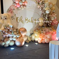 A closer look at the elegant "Oh Baby" baby shower decor, highlighting the beautiful floral-printed backdrop and the intricate arrangement of rose gold, beige, and pink balloons.