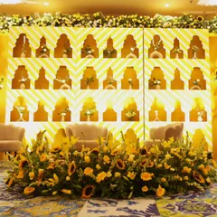 The main stage for the Haldi ceremony. A stunning backdrop with geometric patterns and niches for individual floral arrangements, all in radiant shades of yellow.
