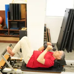 Mr. Harsh Kumar performs a chest press on the reformer. This exercise strengthens his upper body while the machine supports his back, making it a safe and effective way for him to build muscle and improve function.