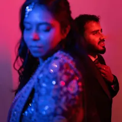 An experimental shot using red and blue gels to create a vibrant, edgy portrait. This shows our willingness to push creative boundaries for a unique look.