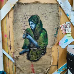 "Mending," an acrylic painting on a repurposed jute bag. It speaks to the act of mending our world with compassion, the very material that defines us.