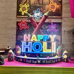 We created this vibrant, large-scale installation for a Holi celebration, featuring custom-lit 'Happy Holi' lettering and oversized pichkari props. This type of illuminated centerpiece becomes the focal point for any festive corporate or private gathering.