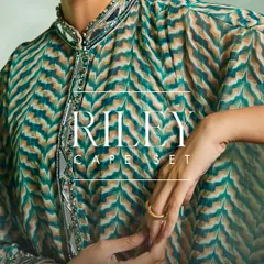 The detailed mirror work and embroidery on the collar and cuffs of the green Riley Cape Set.