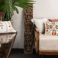 We love mixing textures and patterns. Here, a traditional wooden swing and sofa are adorned with embroidered cushions, placed next to an antique carved wooden panel.