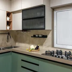A pop of color makes this kitchen feel fresh and modern. The mint green lower cabinets are paired with neutral upper cabinets and a playful black-and-white tiled floor, creating a space that is full of personality.