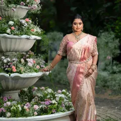 A full view of this stunning engagement look. The pastel pink saree and custom blouse are perfectly complemented by the beautiful floral decor.