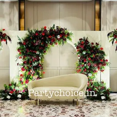 For this sangeet, we created a romantic and dramatic stage with arches of deep red flowers. The dark red roses and foliage stand out against the white backdrop, with hanging chandeliers adding a touch of elegance.