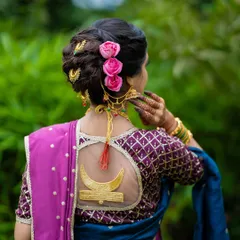 The beauty of a bridal look is in the details. Here, I've created an elegant khopa hairstyle with fresh pink roses, complementing a custom blouse with a sheer back and chandrakor motif, adding a touch of modern artistry to this traditional look.