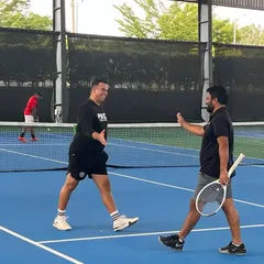 Sportsmanship and camaraderie are at the heart of our Adults Doubles League. Here, two players share a high-five between points.