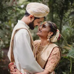 A beautiful candid moment between the bride and groom, lost in each other's eyes. Set against a lush green backdrop, this photo captures the pure love and connection at the heart of the wedding day.