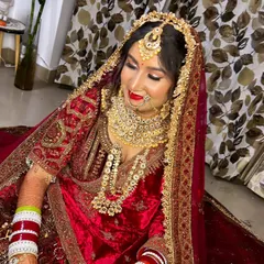 A beautiful downward glance of the bride, showcasing the detailed eye makeup and the traditional nose ring (nath), which are key elements of this heritage look.