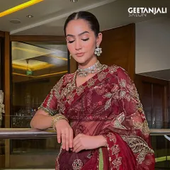 Timeless elegance. This look features a sleek, polished bun and soft, glowing makeup, perfect for a sophisticated bridal or festive style.