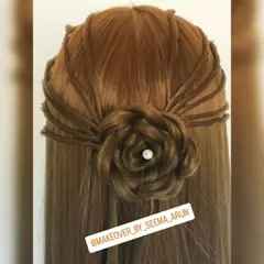 A beautiful half-up, half-down hairstyle featuring an intricate rose made from hair. This romantic style is great for parties and pre-wedding functions.