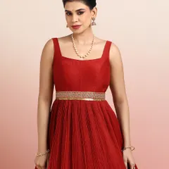 A close-up of the red gown's bodice, showing the elegant square neckline and the embellished golden belt that cinches the waist.