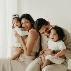A beautiful family portrait with twin daughters. The parents' loving gazes and the children's sweet expressions make this a cherished memory.