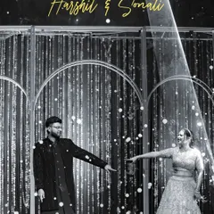 An artistic, black and white shot of the couple on the sangeet stage. The dramatic spotlight and their pose create a cinematic and memorable image of their performance.