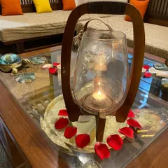 A candlelit lantern with fresh rose petals. It's these small touches that help create a serene and welcoming atmosphere for everyone who visits.