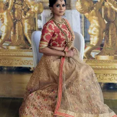 A full view of the sublime cream and red bridal lehenga, showcasing its graceful fall and detailed craftsmanship. This design is ideal for the bride who seeks a sophisticated and classic look.