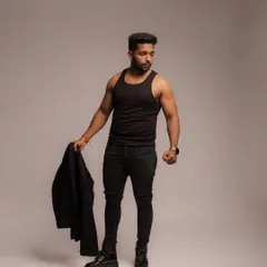 A confident, full-body stance that blends fitness with men's fashion. The simple, all-black outfit highlights the model's athletic build in a subtle, stylish way.
