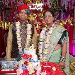 The happy couple stands beside their ornate 50th anniversary cake, ready to celebrate five decades together.