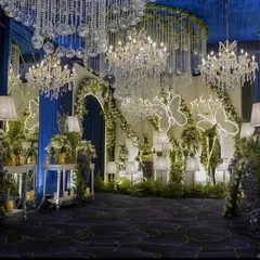 The entrance to the main hall, where guests are greeted by a forest of flowers, illuminated butterfly installations, and a ceiling dripping with crystal chandeliers. It’s a truly magical welcome.