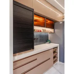 A different angle of the cappuccino-colored kitchen, showing the pull-out pantry drawers and sleek, handleless cabinets. The design ensures that every inch of space is utilized for smart and accessible storage.