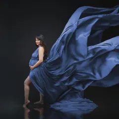 Ethereal elegance. This radiant mama-to-be shines in our golden gown, which we digitally transformed to a serene blue, capturing the essence of new beginnings.
